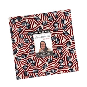 May include: A square fabric bundle featuring a repeating pattern of American flags in red, white, and blue. A small card with the text "America 250 Years" and a woman's portrait is placed on top of the fabric.