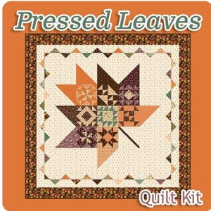 May include: Quilt kit featuring a pressed leaves design. The quilt is made up of a variety of fabrics in shades of brown, orange, green, and white. The quilt is surrounded by a border of brown and orange leaves.