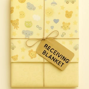 May include: A wrapped receiving blanket with a light yellow background. The wrapping paper is decorated with cartoon bears, cars, stars, and hearts. A brown tag with the words "RECEIVING BLANKET" is tied with twine.