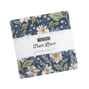 May include: A stack of fabric squares with a floral pattern. The fabric features white daisies, green leaves, and blue accents on a navy background. A white band with the text "True Love" is wrapped around the squares.