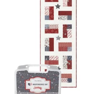 May include: A patriotic-themed fabric panel with red, white, and blue patchwork flag designs and star accents. A clear plastic case with a floral pattern and the text "Independence Day" is in the foreground.