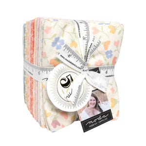 May include: A stack of floral fabric squares tied with a white ribbon printed with measurements. The fabric features a cream background with small blue, orange, and pink flowers. A tag with the Moda Fabrics logo is attached.