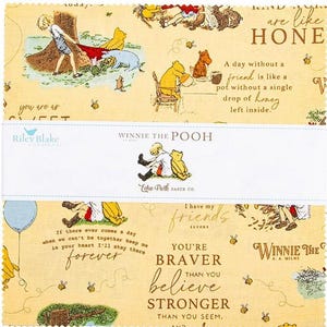 May include: Winnie the Pooh fabric squares with illustrations of Pooh, Piglet, and Christopher Robin. The fabric features quotes like "A day without a friend is like a pot without a single drop of honey left inside." and "You're braver than you believe."