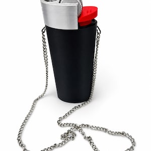 May include: A black lighter-shaped accessory with a silver-colored top and a red button. It features a silver chain for wearing around the neck. The design mimics a classic lighter.