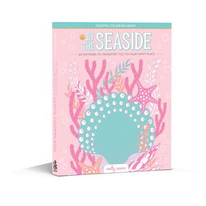 May include: A pink and blue coloring book with the title "By the Seaside" and a seashell illustration. The book features 60 patterns to color.