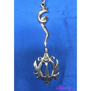 May include: A silver pendant necklace with a unique design featuring a stylized sword and a crescent moon. The pendant is suspended from a silver chain.