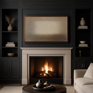 A contemporary living room features dark built-in cabinetry, brass accents, and a soft beige fireplace with warm firelight reflecting across the space. Centered above the mantel, a Samsung Frame TV displays soft beige and earth-toned layers with a diffused central form and subtle textured surface. Designed for Frame TV, this neutral artwork creates a calm, gallery-style presence on a television, blending naturally into modern, Japandi, and minimalist interiors.