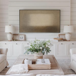 Bright neutral transitional living room with white cabinets, soft furnishings, and layered décor highlighting a Samsung Frame TV on a shiplap wall. The Frame TV features soft beige and earth-toned layers with a diffused central form and subtle textured surface. Designed for Frame TV, this neutral artwork creates a calm, gallery-style presence on a television, blending naturally into modern, Japandi, and minimalist interiors.