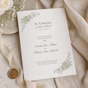 May include: A wedding program featuring the text "St. Catherine of Siena Church" and "The Celebration of Holy Matrimony." The names "Isabella Rose Morgan" and "Anthony James Reynolds" are displayed. Floral illustrations and a wax seal are also visible.