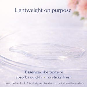 May include: A clear, essence-like liquid sits on a clear, circular dish. The text "Lightweight on purpose" and "Essence-like texture absorbs quickly - no sticky finish" are visible. Pink flowers are in the background.