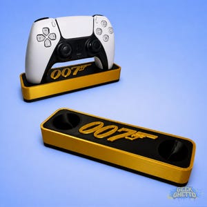 May include: A white and black PlayStation 5 controller rests on a gold and black stand. The stand features the text "007" in gold. A second stand with the same design is below. The background is a gradient of blue.