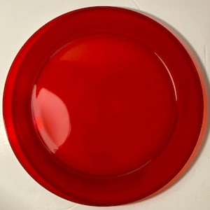 May include: A vibrant red plate with a glossy finish. The plate has a wide, slightly raised rim and a smooth, circular center. The bright red color is consistent across the entire surface, creating a bold and eye-catching design.