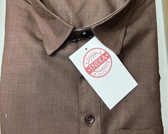 May include: A folded brown button-down shirt with a collar and a small pocket. A tag that says "MADE IN INDIA" is attached to the shirt. The shirt is neatly folded and appears to be new.