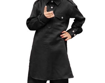 May include: A young child wearing a black kurta pajama set. The long-sleeved shirt has a button-down collar, a chest pocket, and buttoned cuffs. The matching pants are loose-fitting. The child is wearing gold-colored shoes.