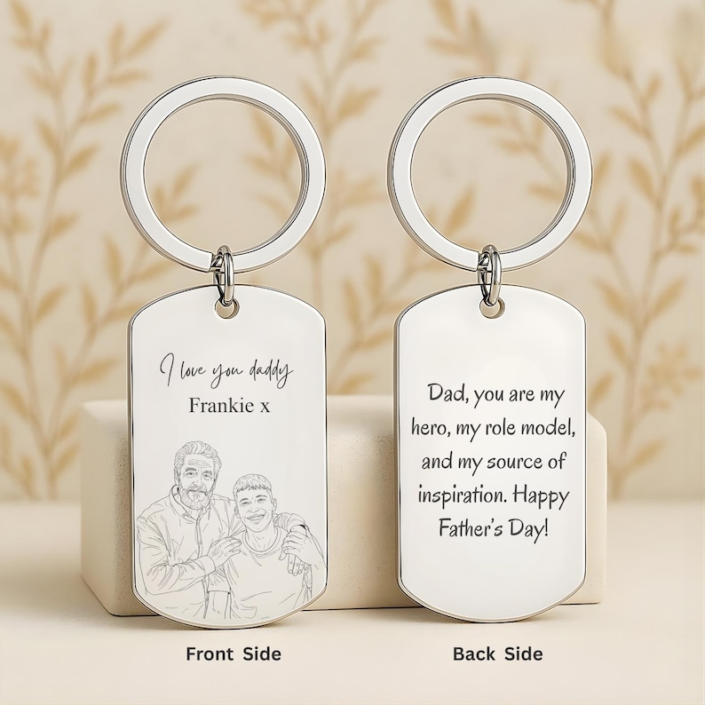 May include: Two silver-toned metal dog tag keychains with circular rings. The front tag features an engraved line drawing of two people with the text I love you daddy Frankie x. The back tag features the engraved text Dad, you are my hero.