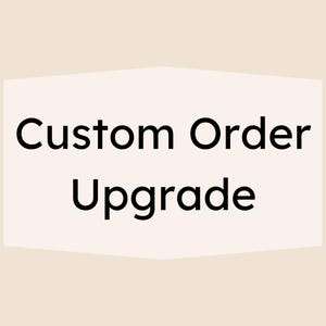 May include: A light beige background with a white, geometric shape containing the words "Custom Order Upgrade" in black, sans-serif font. The text is centered within the shape, which has a subtle, angled design.