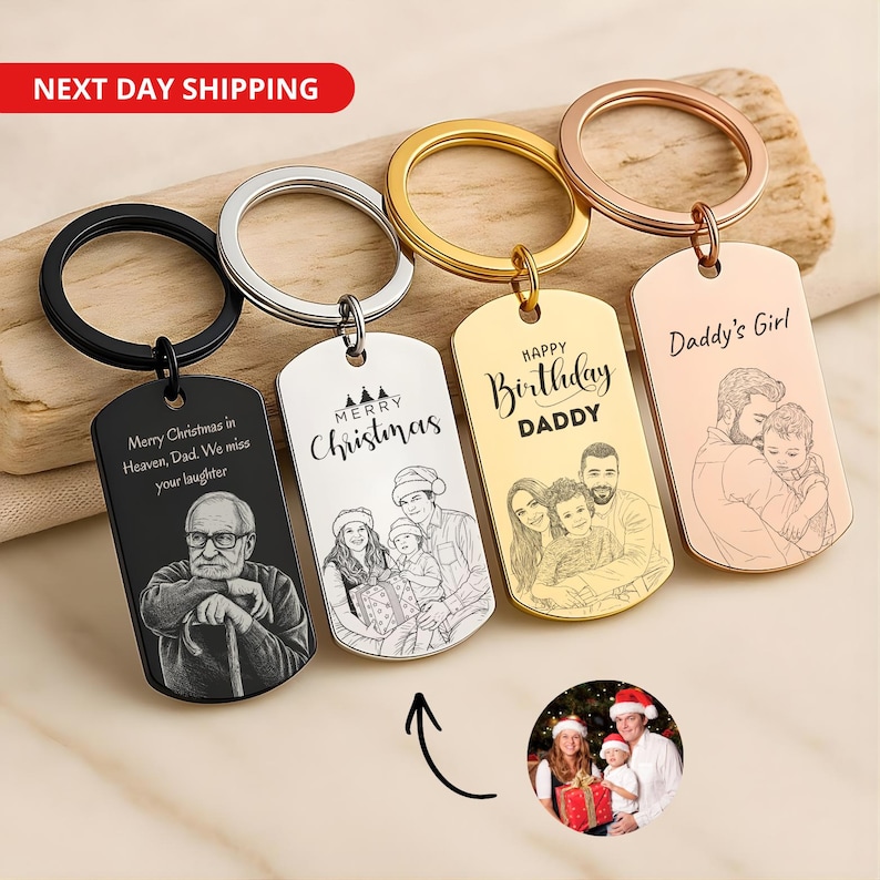 May include: Four rectangular metal keychains with split rings, featuring custom laser-engraved portraits and text. The keychains are black, silver, gold, and rose gold. Engravings include "Merry Christmas in Heaven, Dad," "Merry Christmas," "Happy Birthday DADDY," and "Daddy's Girl."