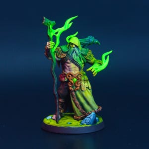 May include: A miniature fantasy figure of a wizard with a long beard, staff, and raven on his shoulder. The figure is painted with vibrant colors, including green, brown, and blue, and stands on a circular base. The wizard's staff and hands glow with a bright green light.