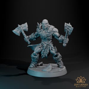 May include: A grey miniature figure of a muscular warrior holding two battle axes. The figure is bald and wears armour, a loincloth, and furry boots. The figure stands on a circular base. The Zen Lienzo Miniatures logo is in the bottom right corner.