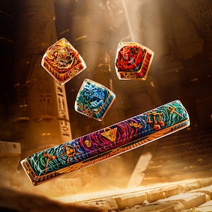 May include: A set of custom keycaps with an Egyptian theme. The keycaps feature intricate designs in red, blue, and gold, with symbols and hieroglyphs. The set includes a long, rectangular spacebar and three square keycaps.