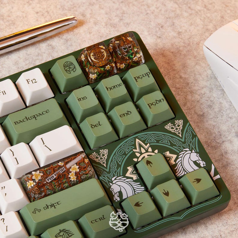 May include: A mechanical keyboard featuring olive green and white keycaps with custom artisan keys. The keyboard frame displays intricate white line art of horses and Celtic-style patterns. Specific keys include Backspace, Shift, Ctrl, and arrow keys.