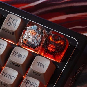 May include: Custom keyboard with artisan keycaps. One keycap features a detailed wizard design, and another depicts a fiery demon. The other keys are brown with white lettering, including "PRT SCR", "HOME", and "PGUP".