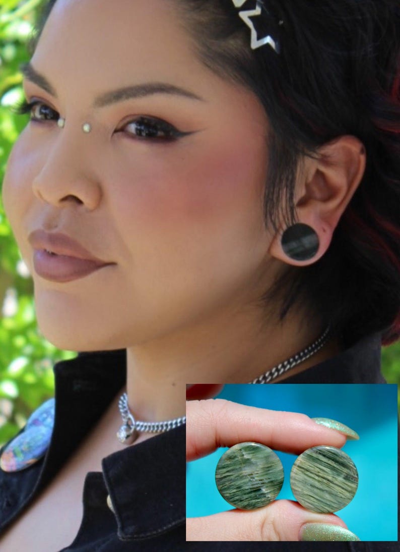 A bold pair of Green Jasper Double Flare Plugs sits elegantly on a neutral surface, radiating natural strength and earthy charm. Each plug is carved from genuine Green Jasper, showcasing deep olive and forest tones, marbled with organic patterns of b
