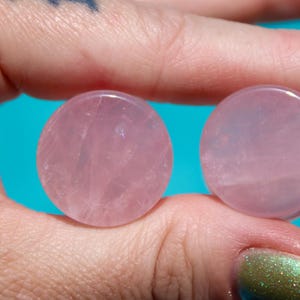 May include: Two round pink rose quartz plugs for stretched earlobes.