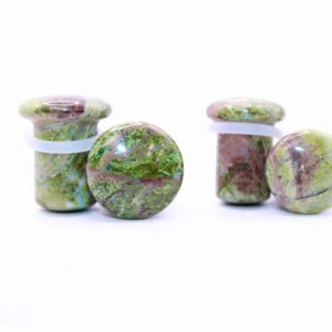May include: Two pairs of green and maroon stone ear plugs with a white band. One pair is cylindrical, and the other is spherical. The plugs are made of a natural stone material and are set against a white background.