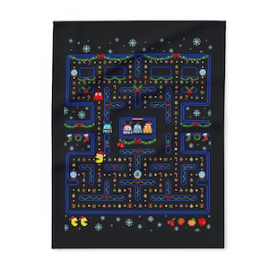 Pode incluir: Cobertor preto com um design de Natal Pac-Man pixelizado. O design inclui um labirinto com Pac-Man, fantasmas e decorações de férias como enfeites, flocos de neve e guirlandas. Um item festivo e divertido.