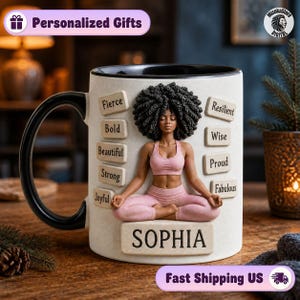 May include: A white ceramic mug with a black handle and interior, featuring a 3D-style illustration of a person with dark curly hair in a yoga pose. Rectangular tiles surround the figure with the words Fierce, Bold, Beautiful, Strong, Joyful, Resilient, Wise, Proud, and Fabulous. The name SOPHIA is printed on a larger tile at the base.