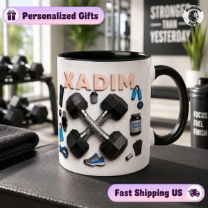 Peut inclure: Un mug en céramique blanche avec une anse et un intérieur noirs, portant le nom XADIM en lettres en relief. Le motif comprend des illustrations de deux haltères croisés, un pot de protéines marqué XADIM, une corde à sauter bleue, une basket et un gant.