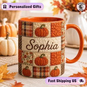 May include: A ceramic mug with an orange interior and handle, featuring a patchwork quilt design of pumpkins, plaid patterns, and floral motifs in shades of orange, brown, and cream. The name Sophia is printed in brown script in the center.