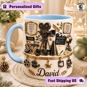 May include: A cream-coloured ceramic mug with a light blue interior and handle. The exterior features raised, three-dimensional movie-themed icons including a camera, director's chair, and clapperboard. The name David is printed in script.
