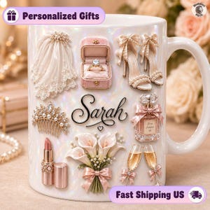 May include: A white iridescent ceramic mug featuring a personalised name Sarah in black script. The mug is decorated with 3D-style illustrations of a bridal veil, a ring in a pink box, high heels, a tiara, perfume, lipstick, calla lilies, and champagne flutes.