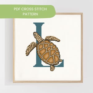 Puede incluir: Patrón de punto de cruz enmarcado con una tortuga marina marrón y beige y la letra "L" en verde azulado sobre un fondo blanco. El texto "PDF CROSS STITCH PATTERN" está en una pancarta verde. Ideal para manualidades.