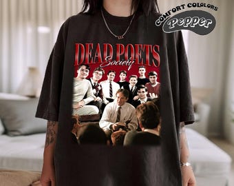 Könnte beinhalten: Schwarzes T-Shirt mit einem Vintage-Grafikdruck der Besetzung des Films "Dead Poets Society" mit dem Titel "Dead Poets Society" in roter Schrift über dem Bild.
