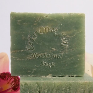 May include: A green bar of soap with the text "Cedar Creek Soaps" and "Handcrafted Soaps" embossed on the top.
