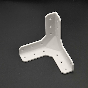 May include: A white three-way corner bracket featuring a rigid L-shaped design with multiple pre-drilled circular holes along each of its three arms. The component is constructed with a smooth finish and is intended for structural assembly.