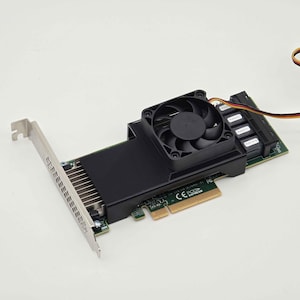 May include: A computer component, a black and green PCI Express card with a cooling fan. The card has a silver bracket and multiple ports. The fan is black and sits atop a black heatsink.