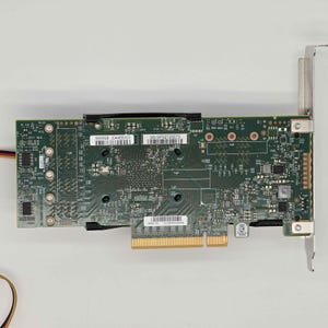 May include: A green circuit board with various electronic components, including chips, connectors, and small circular elements. The board has a gold-colored connector at the bottom and a metal bracket on the right side. The text "500062B 204ABDACO" and "SN: SP92728073" are visible.