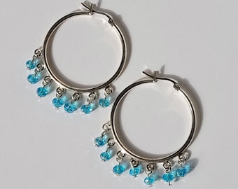 Silver hoop earrings with light blue crystals