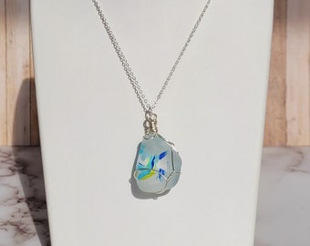 Art glass pendant with blue, green, and yellow markings, wire wrapped on a silver chain