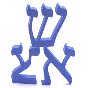May include: A blue wooden sculpture of the Hebrew word "Shem". The letters are stylized and stand upright against a white background. The sculpture is painted in a solid, medium blue color.