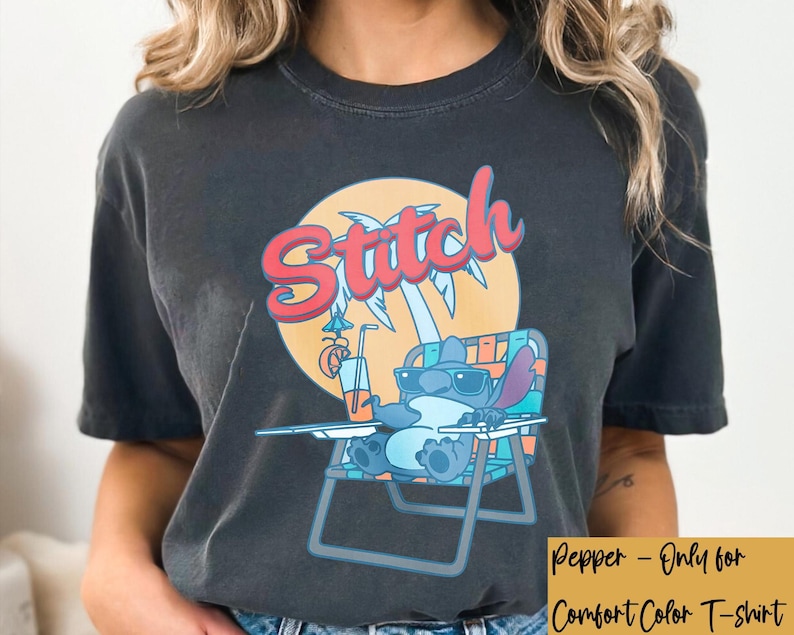 May include: Dark gray Comfort Color t-shirt featuring a cartoon Stitch character relaxing in a beach chair. The graphic includes the word "Stitch" in red and blue, a palm tree, and a drink with a straw.