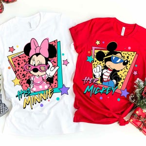 K&ouml;nnte beinhalten: Zwei T-Shirts mit Disney-Figuren. Ein wei&szlig;es T-Shirt mit Minnie Mouse in einem rosa Kleid und Sonnenbrille, mit dem Text "His Minnie". Das andere ist rot mit Mickey Mouse mit Sonnenbrille, mit dem Text "Her Mickey".