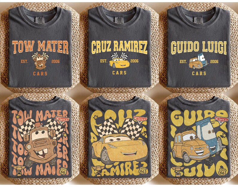 May include: Six charcoal gray t-shirts featuring designs from the Cars movie. Each shirt displays a different character's name in a vintage font, along with an image of the character and the text "Cars" and "EST. 2006".