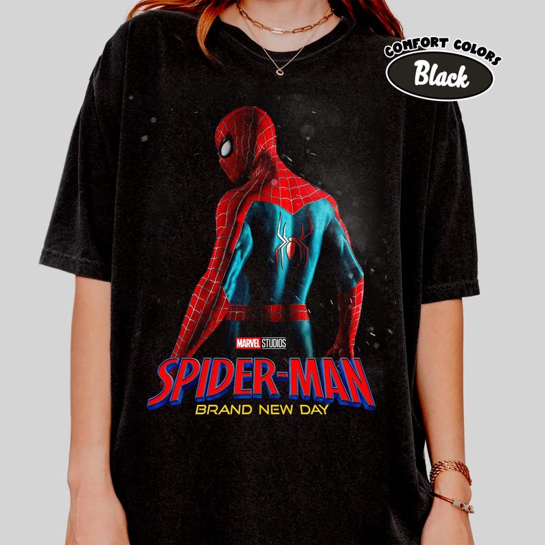 May include: Black t-shirt with a graphic of Spider-Man in a red and blue suit, and the text "SPIDER-MAN BRAND NEW DAY" in red and blue. The shirt has a "Comfort Colors Black" label.