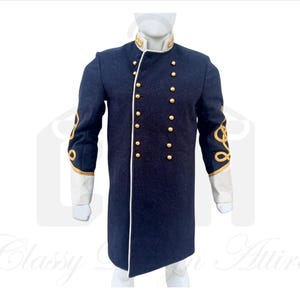 Könnte beinhalten: Ein dunkelblauer Frack mit goldenen Knöpfen und Verzierungen. Der Mantel hat einen Stehkragen und lange Ärmel mit weißen Manschetten. Die Ärmel sind mit goldenen Litzen verziert.