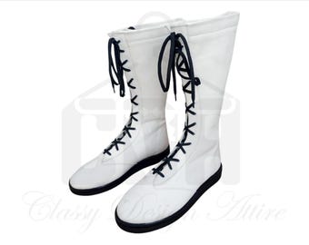 May include: Pair of white wrestling boots with black laces. The boots are tall and have a flat sole.